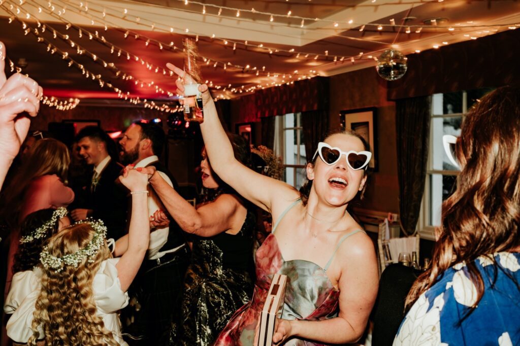 Woman holding a drink having fun on the dance floor