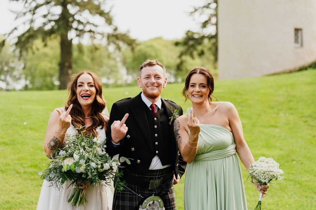 Bride and Groom having fun with a bridesmaid in green dress