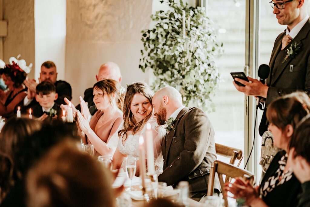 Couple having an intimate moment during wedding speeches