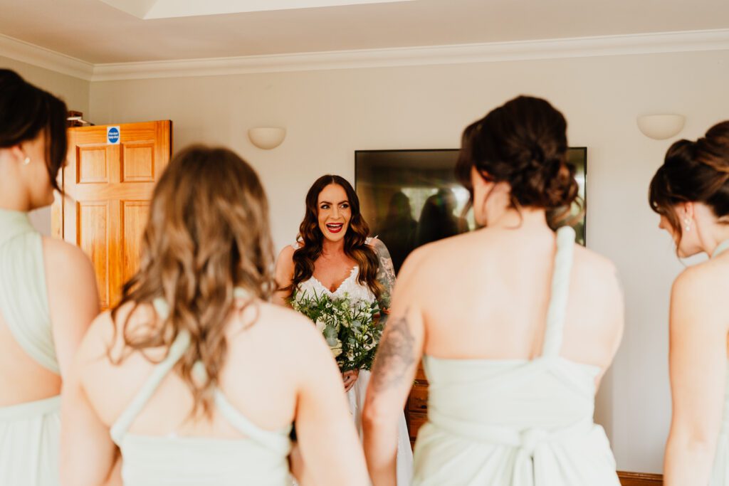 bride looking happy as she looks at her bridemaids