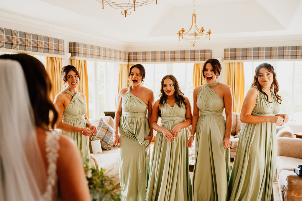 five bridemaids standing and looking at bride with surprised expression