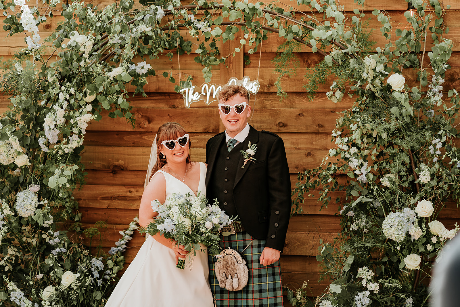 Couple standing in front of wooden wall for their rustic wedding at Elrick House, Scotland