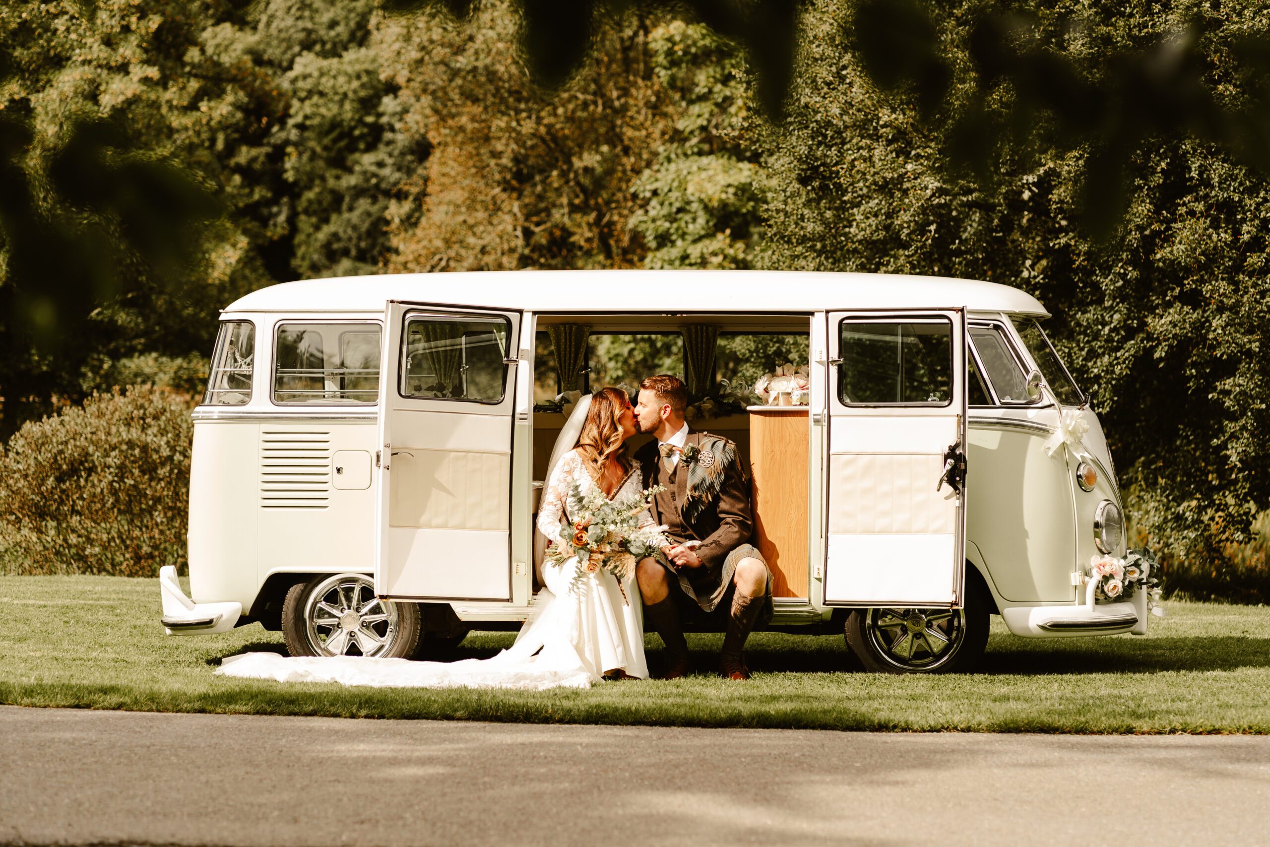 Couple sitting in a camper van for their wedding at Aswanley