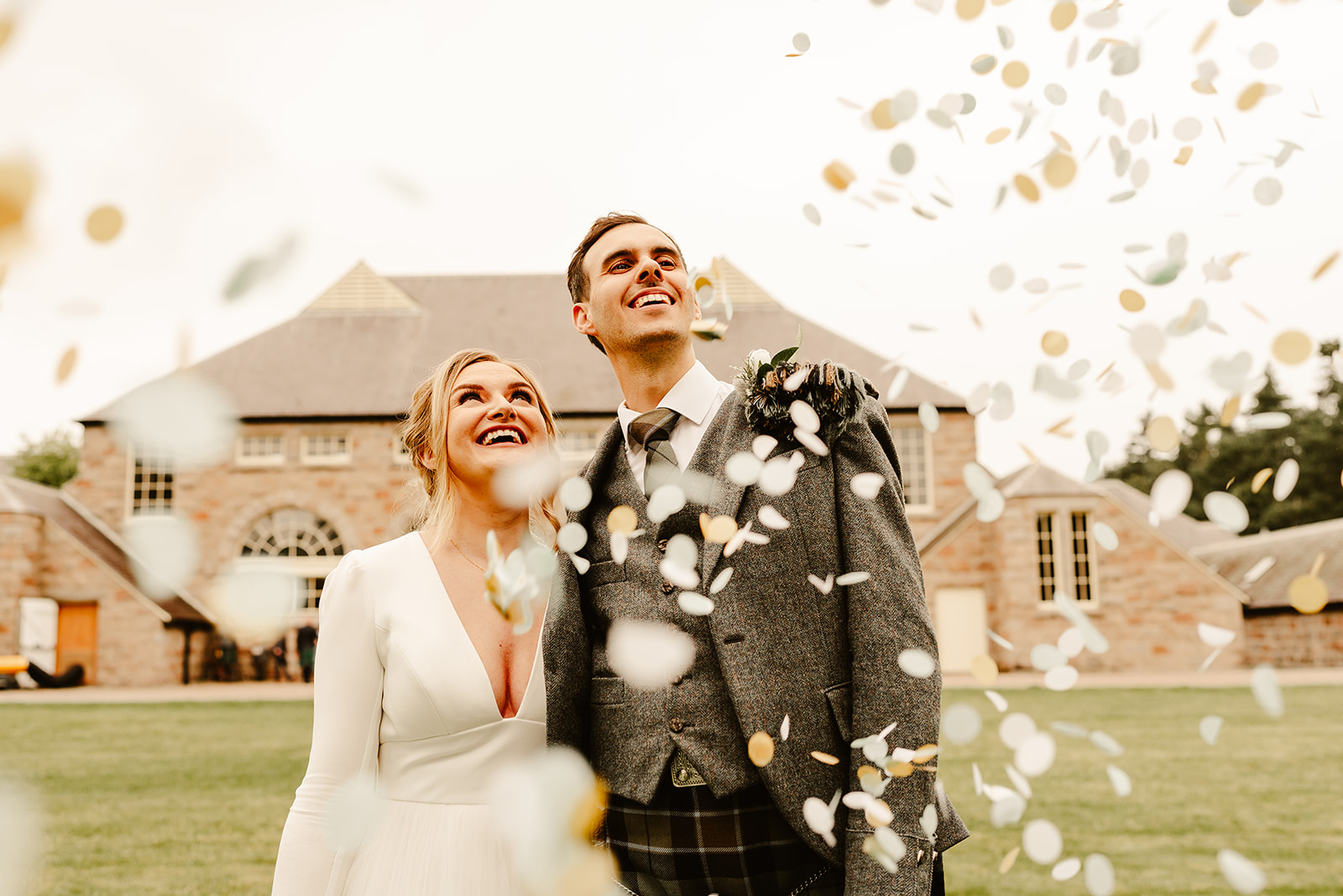 Picture of a couple looking up through confetti with The Coos Cathedral in the background