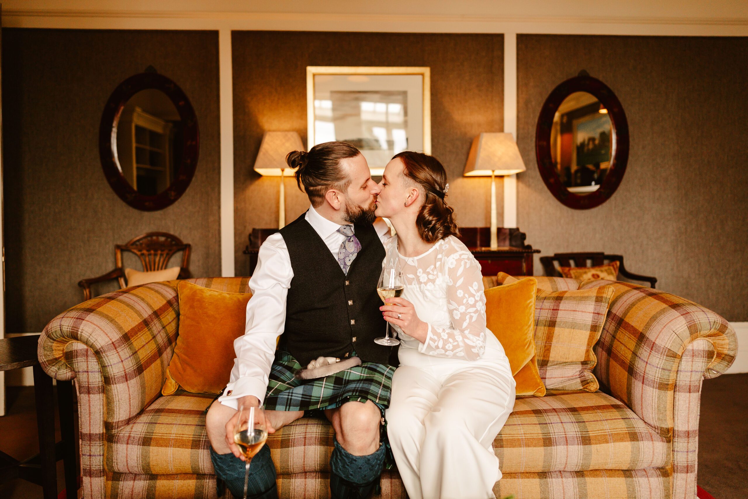 bride and groom cuddle on sofa during intimate scottish elopement at douneside hosue