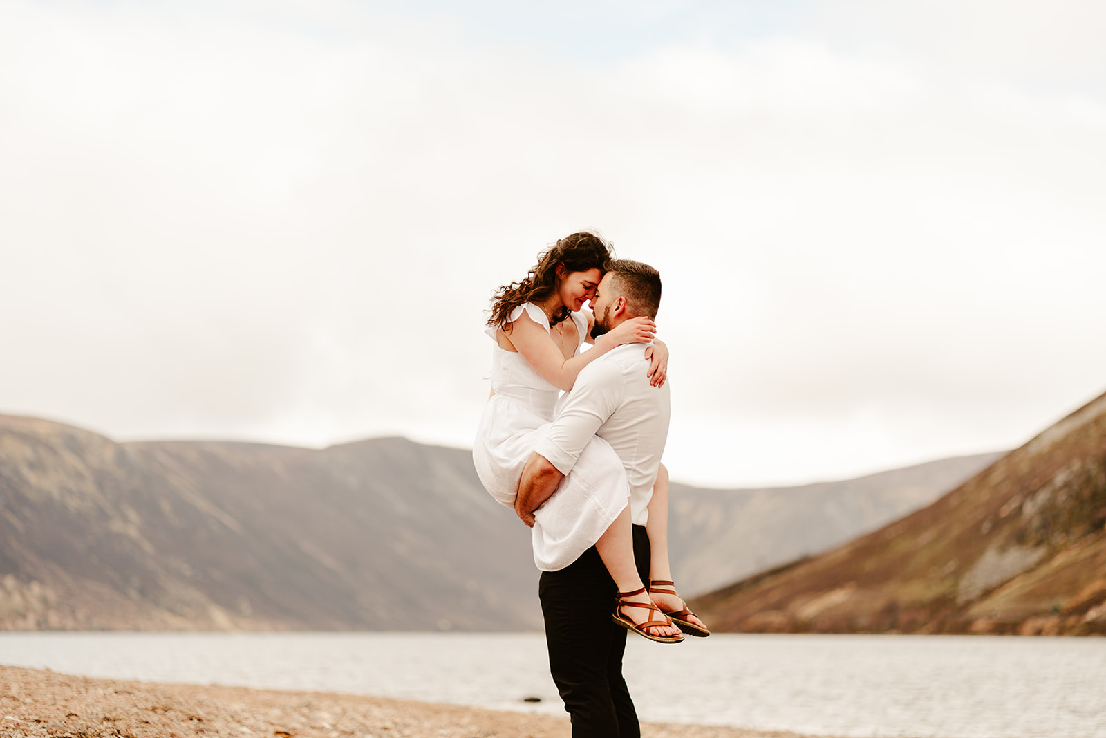 couple kiss at scottish engagement photoshoot at loch muick