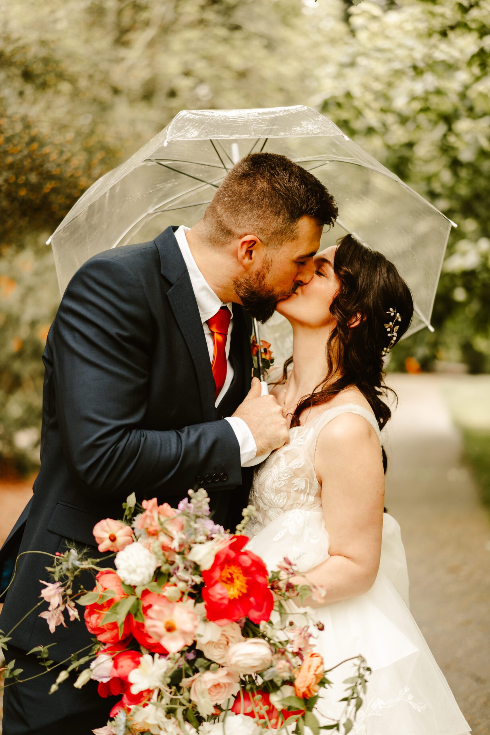 Couple kiss under umbrella at hazlehead park wedding, aberdeen