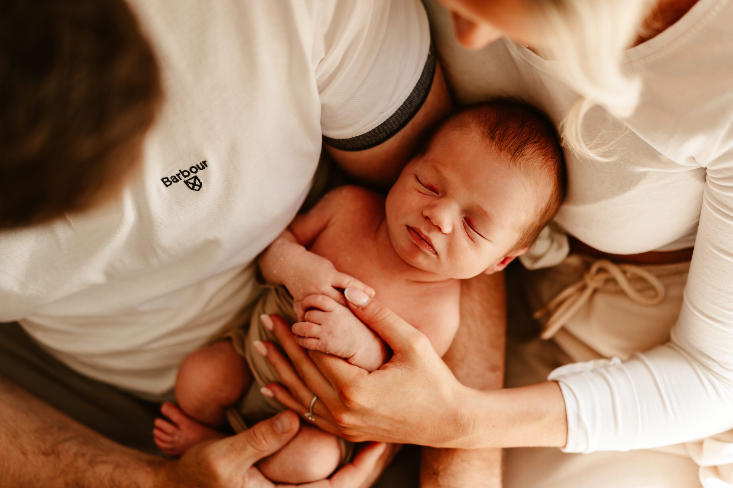 Newborn baby in parents arms adoring at home newborn photos in aberdeen