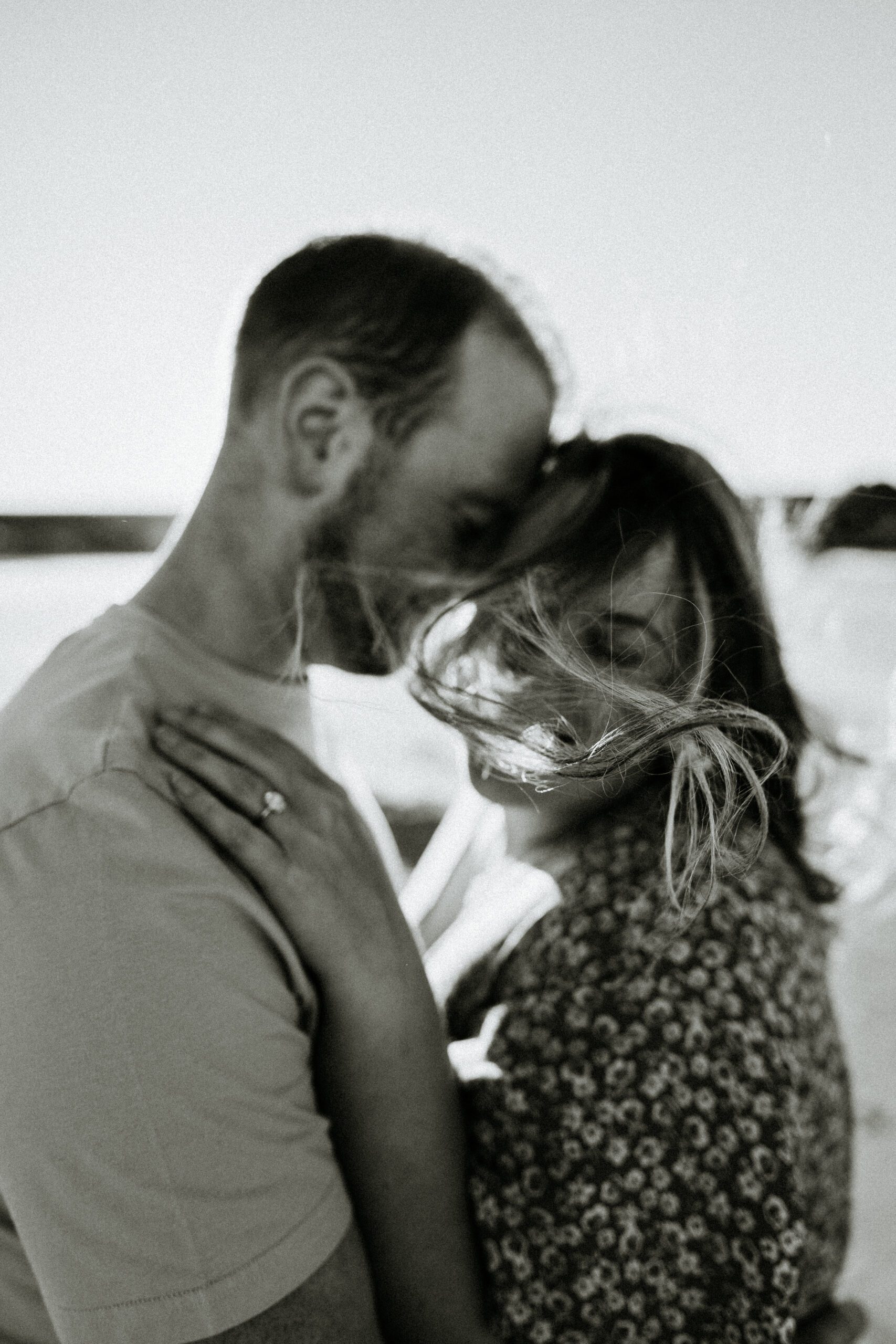 man and woman embrace during sandend beach engagement photoshoot