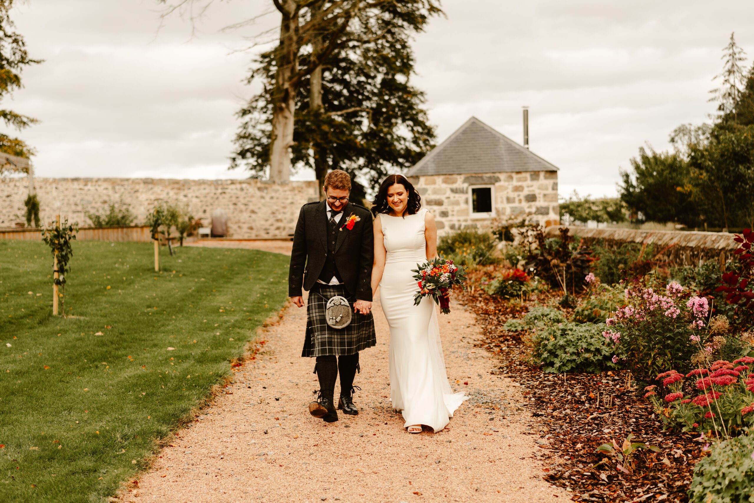 bride and groom walk in the gardens at Elrick House wedding venue