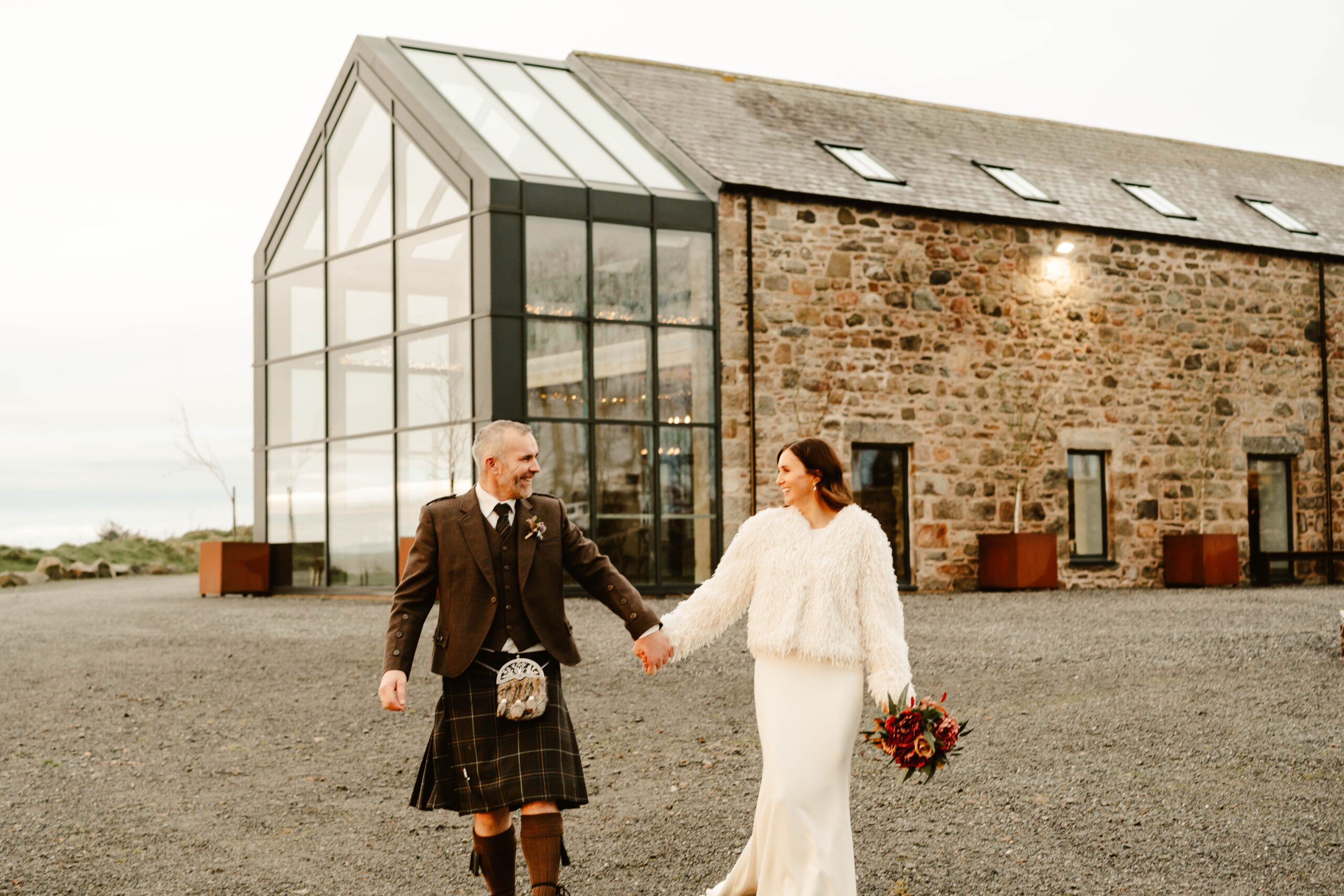 bride and groom walk outside at winter wedding at schivas steading